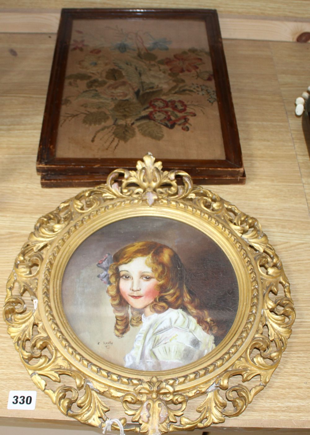 A gilt framed oil portrait of a young lady signed E. Reilly, diameter 22cm, overall 40cm, and two woolwork floral panels, 37 x 26cm